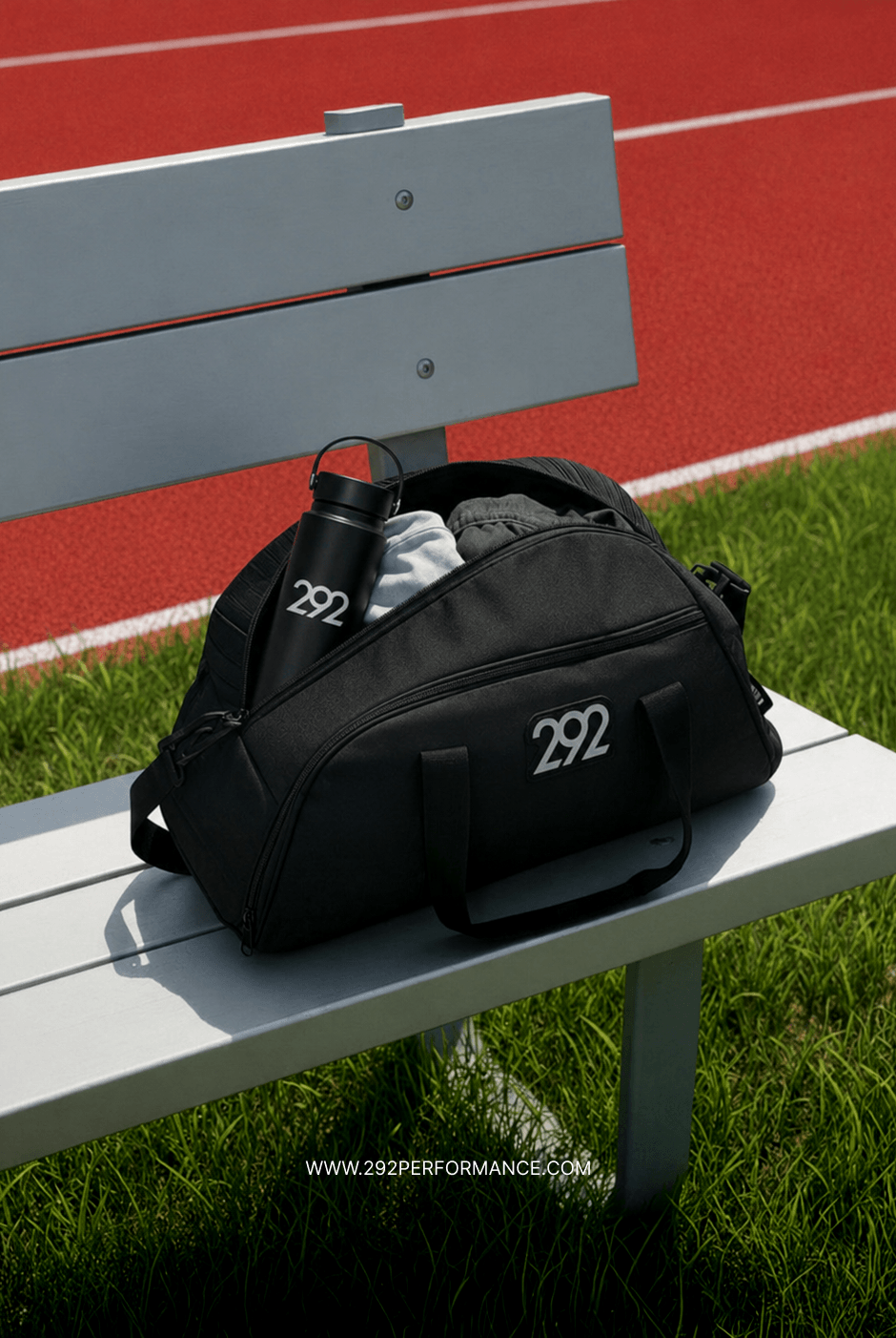 Branded kit bag and water bottle on a bench beside the track